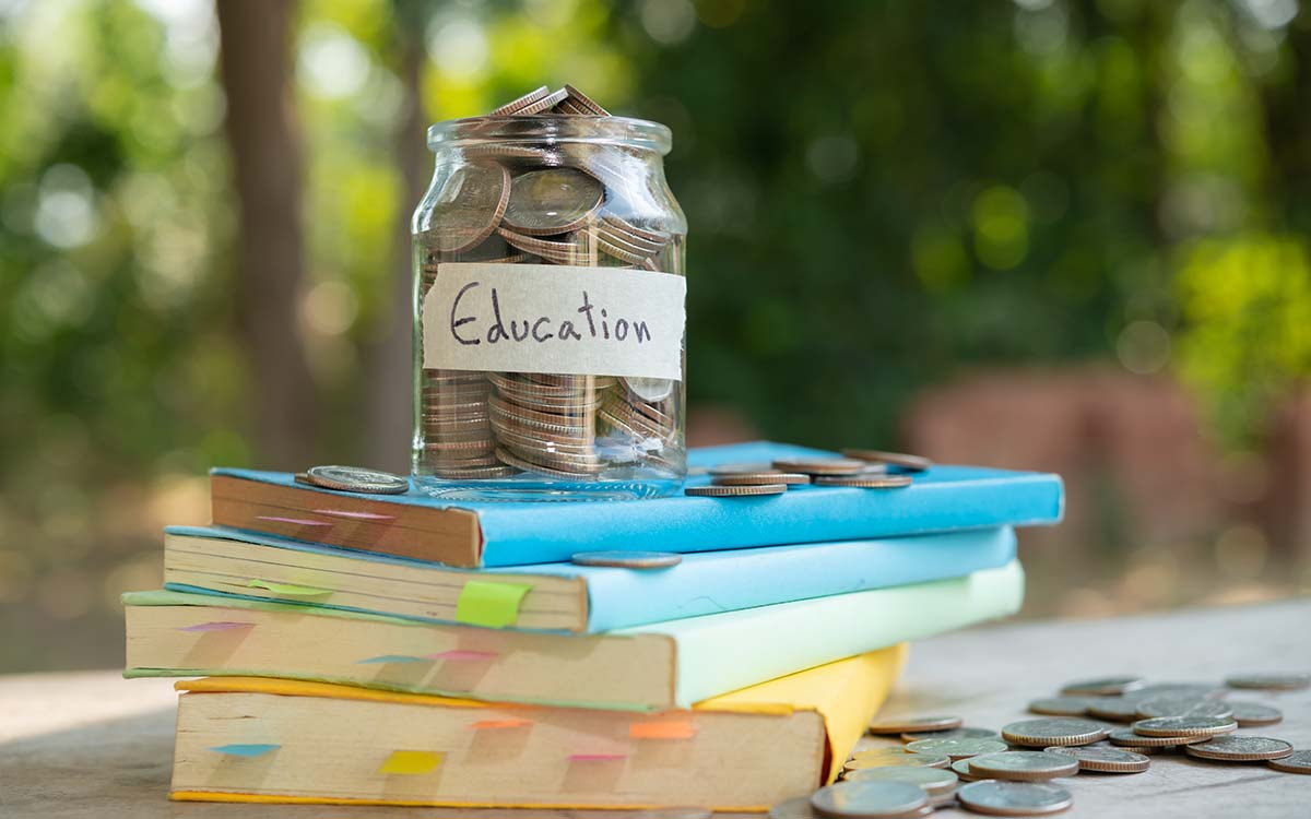 Education savings jar on a stack of books representing study abroad application planning